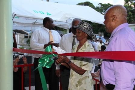 Ms. Eglantine Duberry cuts the ribbon to the new Barnes Ghaut Adult Education Centre with (second from left) Premier of Nevis Hon. Joseph Parry and (R) Minister of Social Development Hon. Hensley Daniel